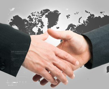 Businessmen shaking hands against an hi-tech background